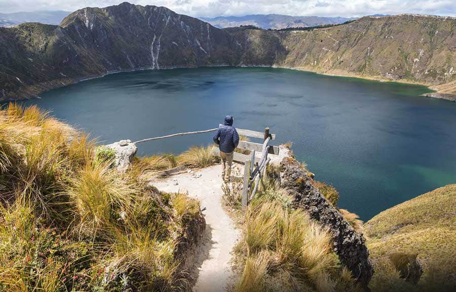 Hiker overlooking scenic mountain crater lake