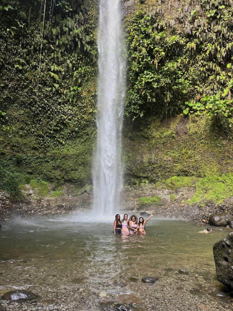 People enjoying a natural waterfall pool