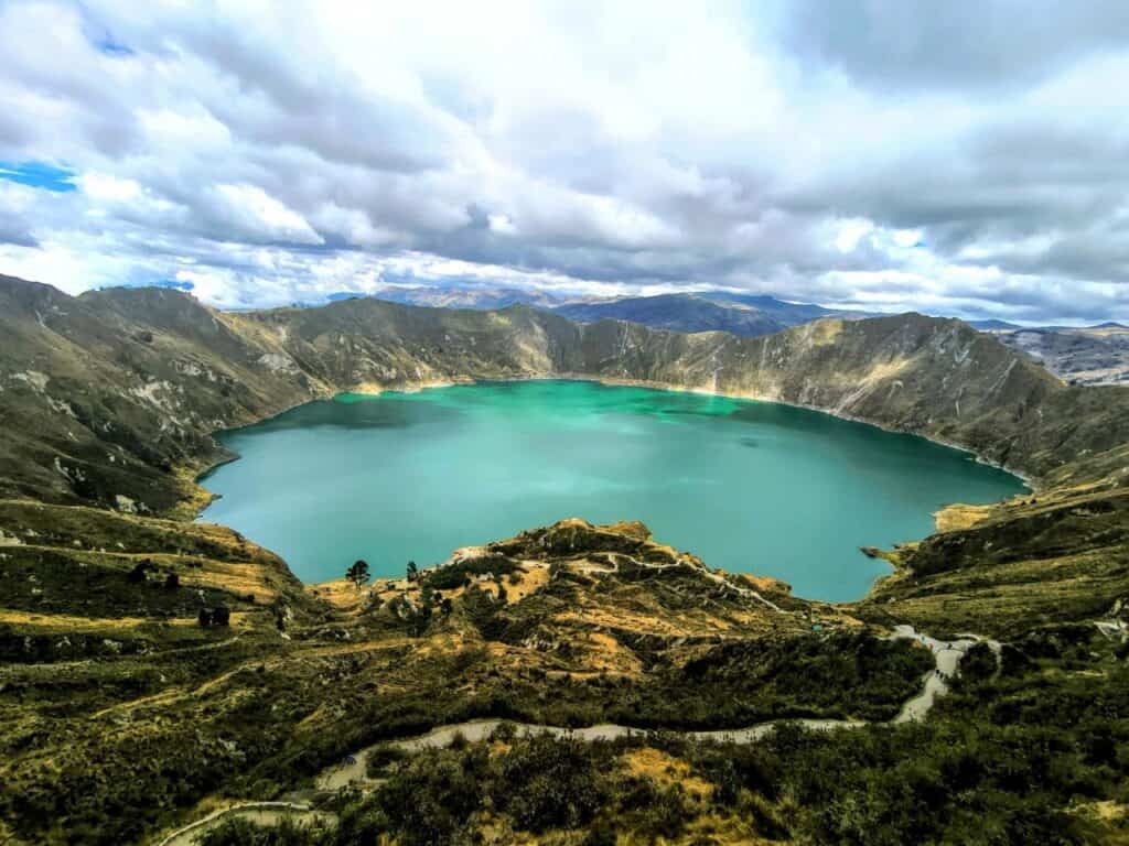 Turquoise lake surrounded by mountains and clouds