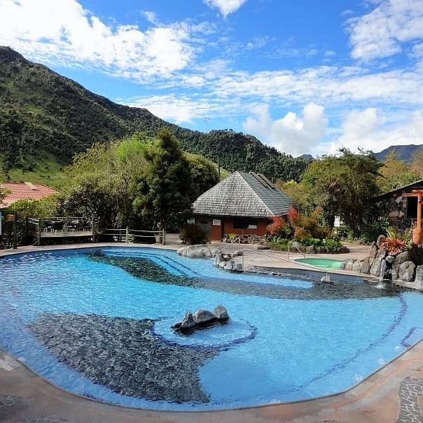 Outdoor thermal pool surrounded by mountains and trees