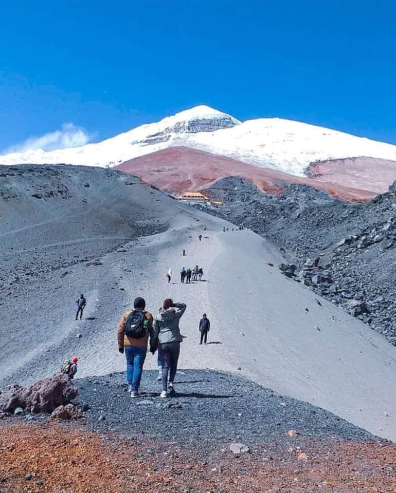 Hikers walking toward a snow-capped mountain