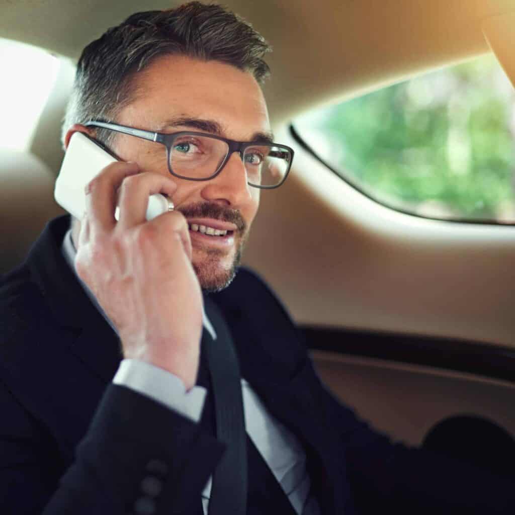 Businessman talking on phone inside car